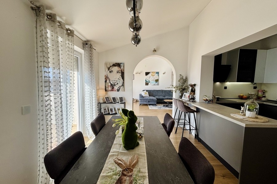 Otvorený jedálenský kút s prístupom do kuchyne a množstvom prirodzeného svetla