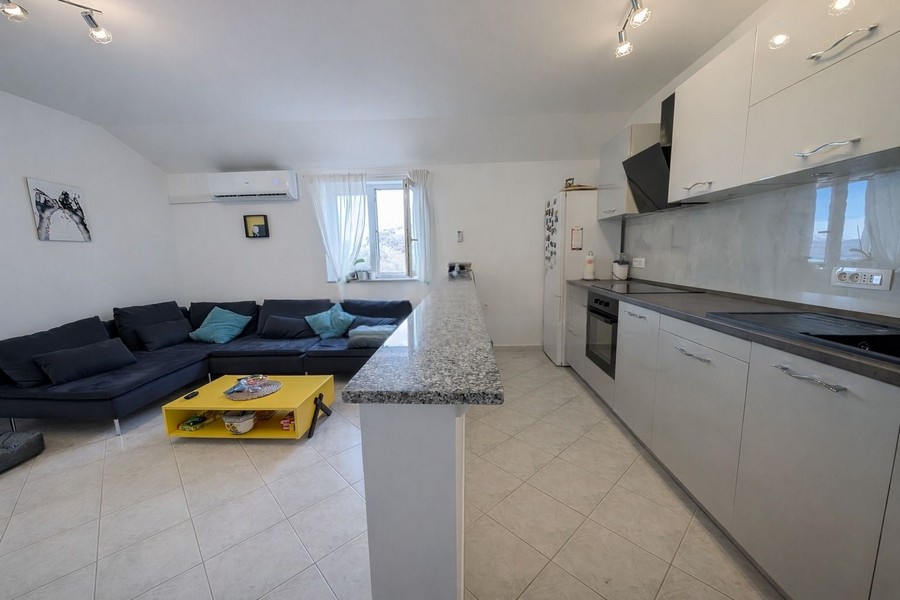 Moderný obývací priestor s otvorenou kuchyňou a pohovkou