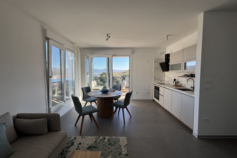 Svetlá obývacia izba s veľkými oknami a výhľadom na more