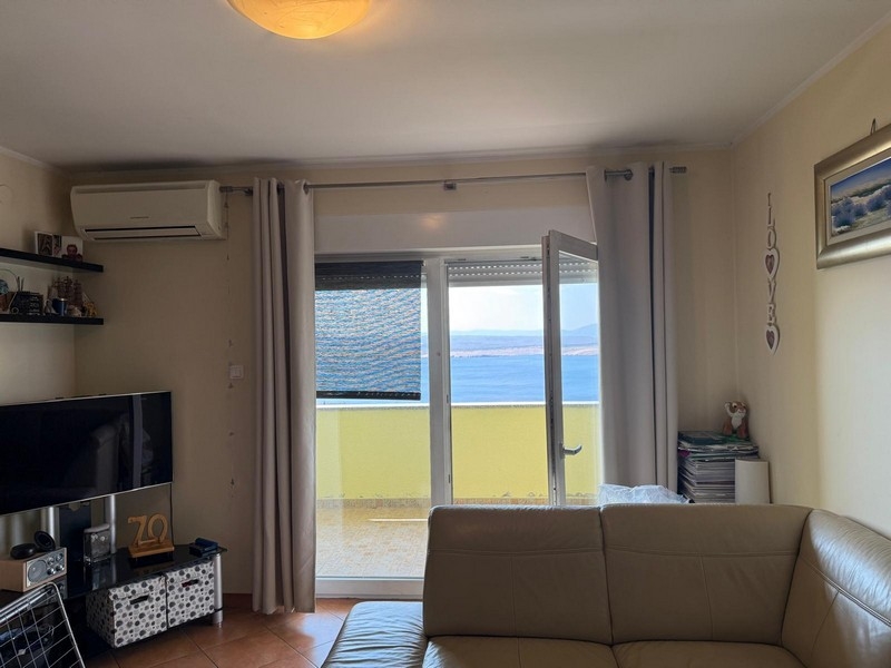 Obývacia izba s prístupom na balkón a výhľadom na more