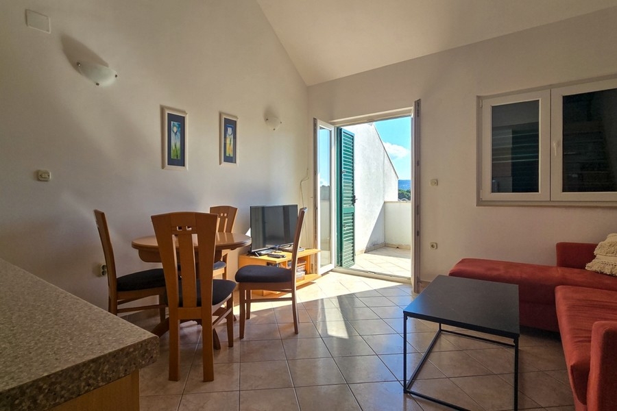 Obývacia izba so vstupom na balkón a množstvom prirodzeného svetla