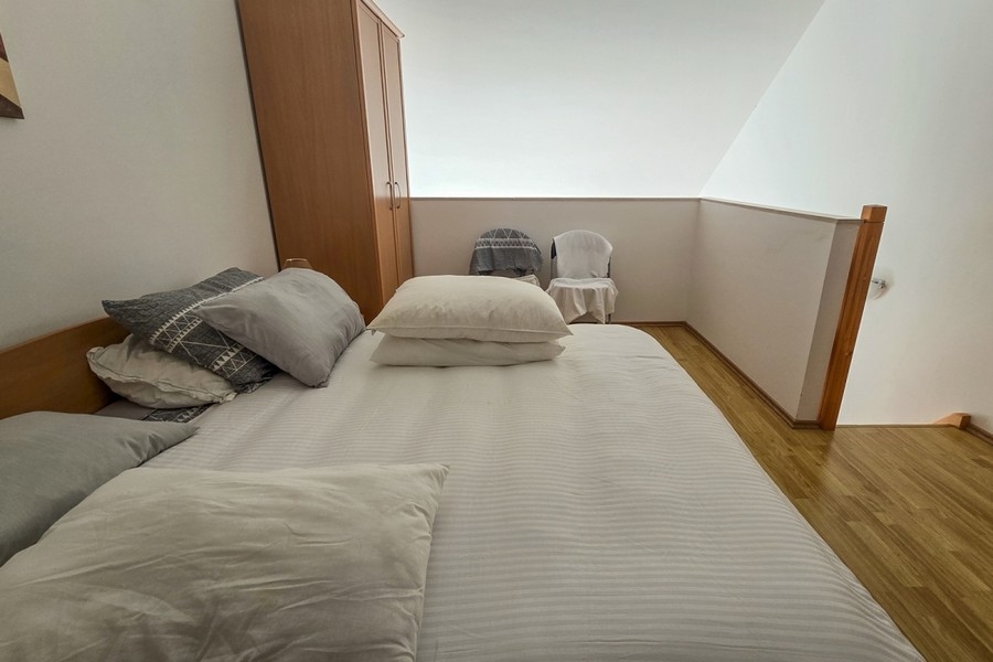 Spací priestor na galérii s manželskou posteľou a šatníkovou skriňou