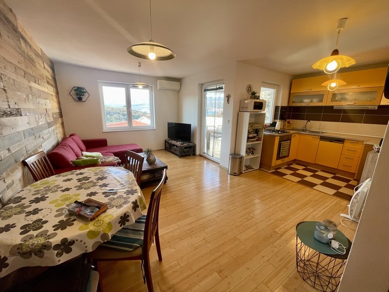 Obývacia izba s otvorenou kuchyňou a prístupom na balkón s výhľadom na more