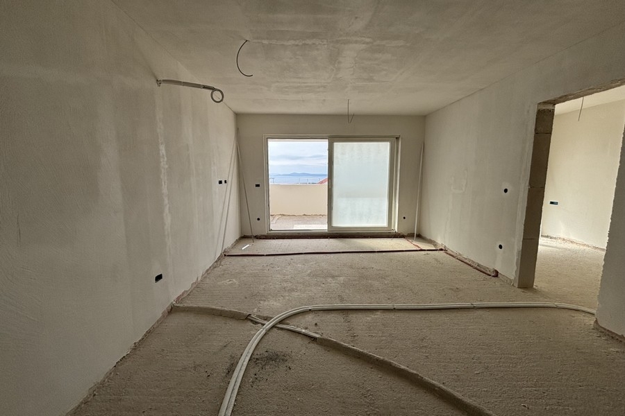 Vnútorný pohľad na otvorený obývací priestor s výhľadom na kuchyňu a chodbu