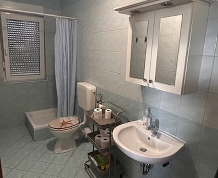 Kúpeľňa so sprchovacím kútom, umývadlom a oknom