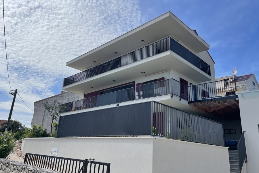 Svetlý obývací priestor a jedálenský kút s veľkými oknami a výhľadom na more