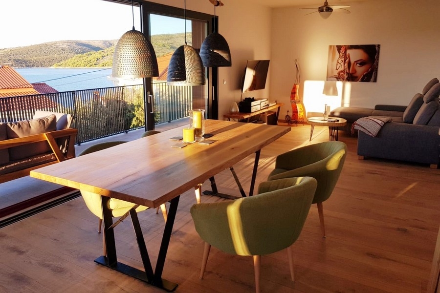 Otvorený obývací priestor s pohovkou, jedálenským stolom a prístupom na balkón