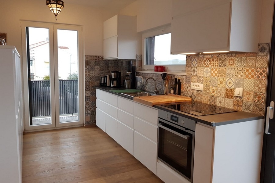 Moderná kuchynská linka so vstavanými spotrebičmi a ozdobným obkladom