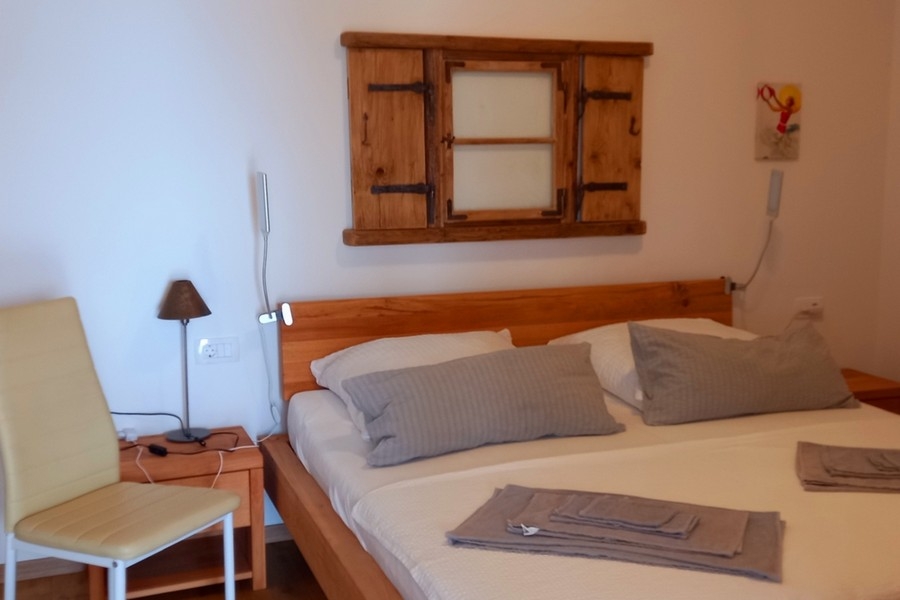 Spálňa s manželskou posteľou a jednoduchým zariadením