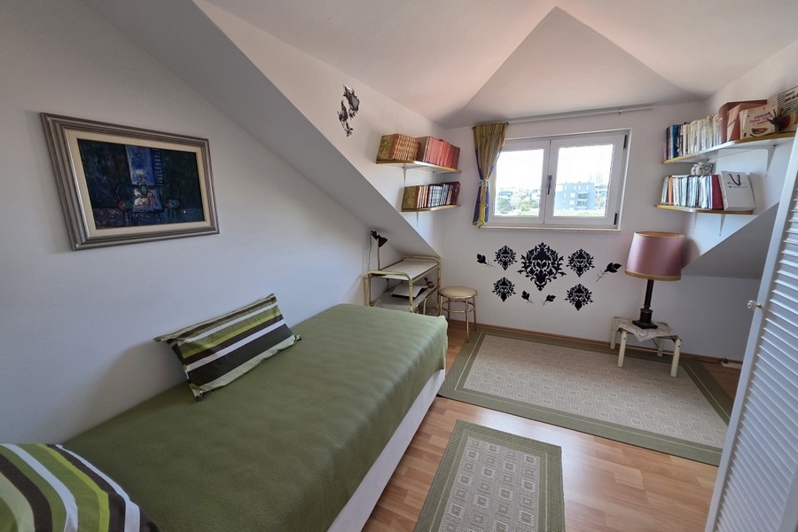 Svetlá podkrovná spálňa s jednolôžkom, pracovným kútom a šikmými stropmi