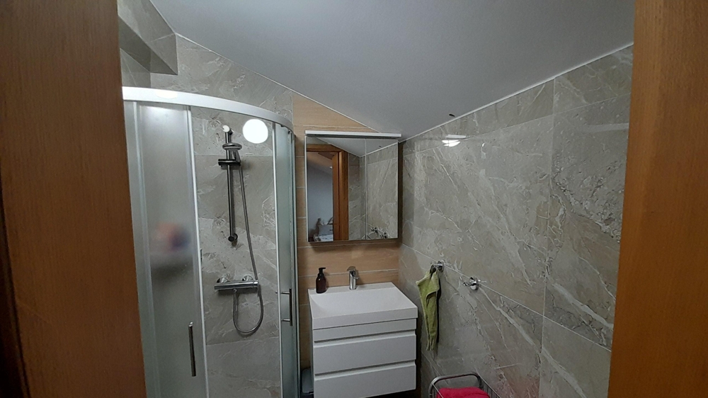 Moderná kúpeľňa so sprchovacím kútom a umývadlom