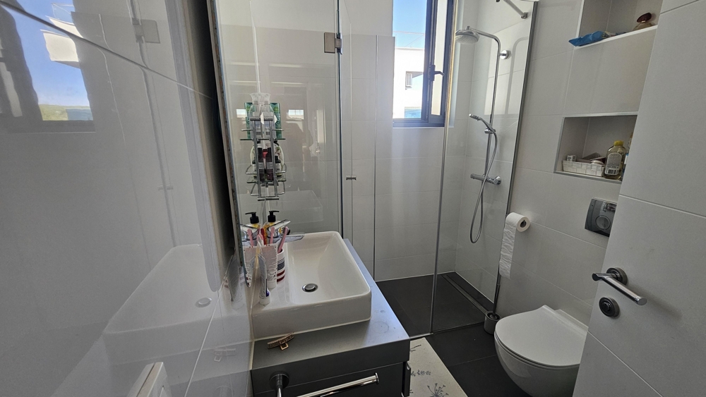 Moderná kúpeľňa so sprchovacím kútom a oknom