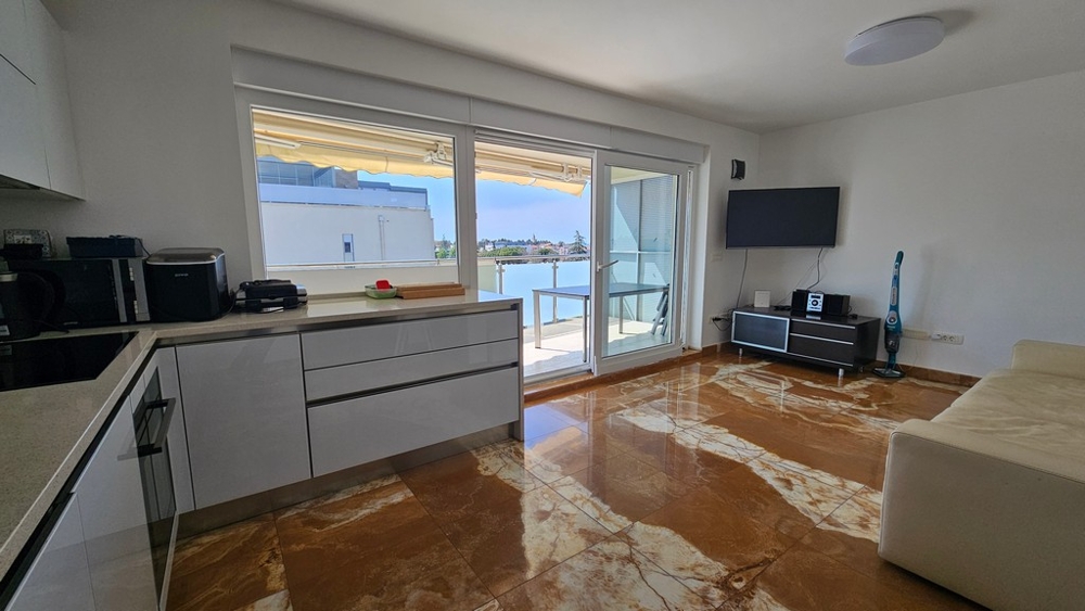 Obývacia izba s kuchyňou a vstupom na balkón s výhľadom na more