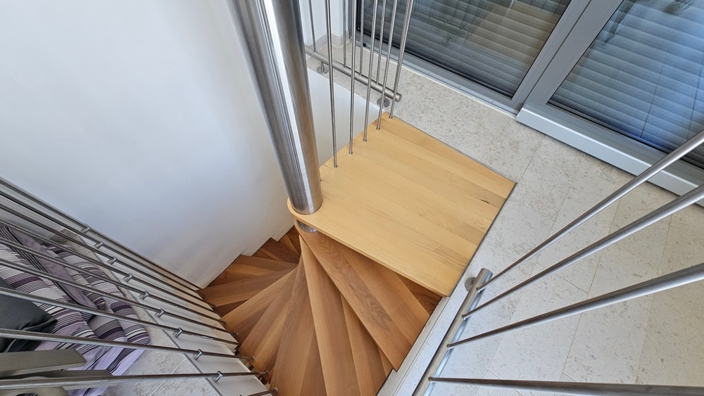 Interiérové ​​schodisko s drevenými stupňami a moderným zábradlím