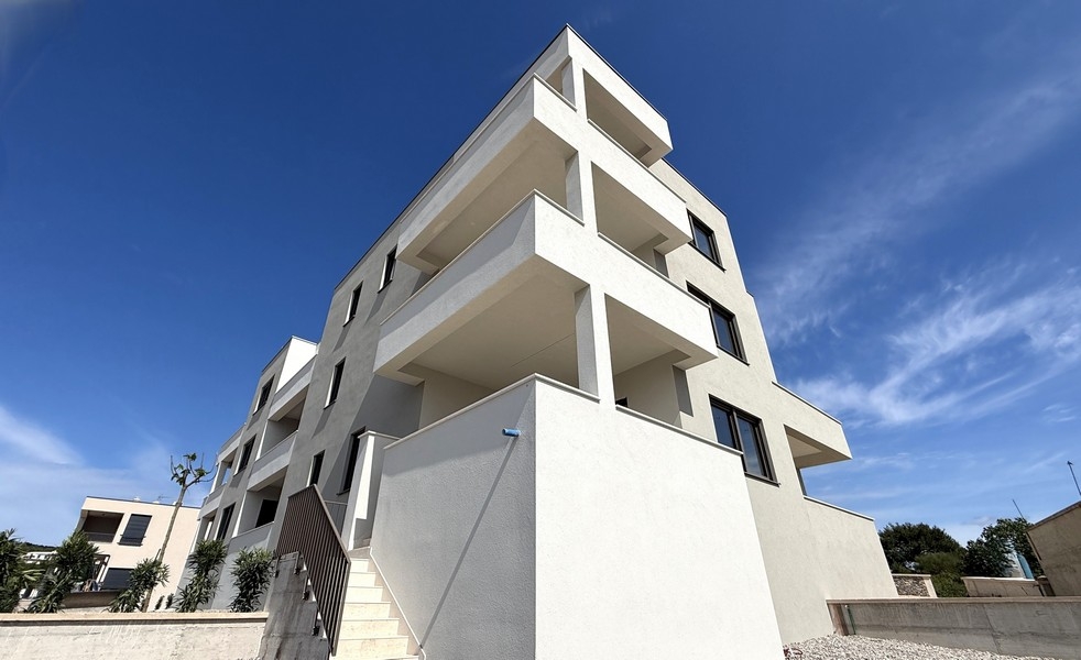 Moderná nová budova s ​​jasnou architektúrou a balkónmi