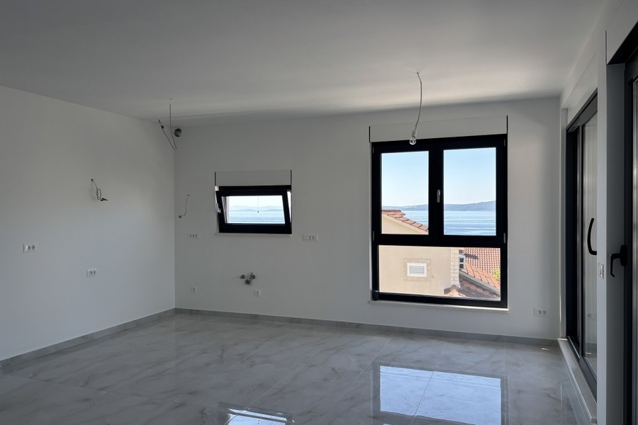Otvorená obývacia izba s prístupom na balkón a výhľadom na more