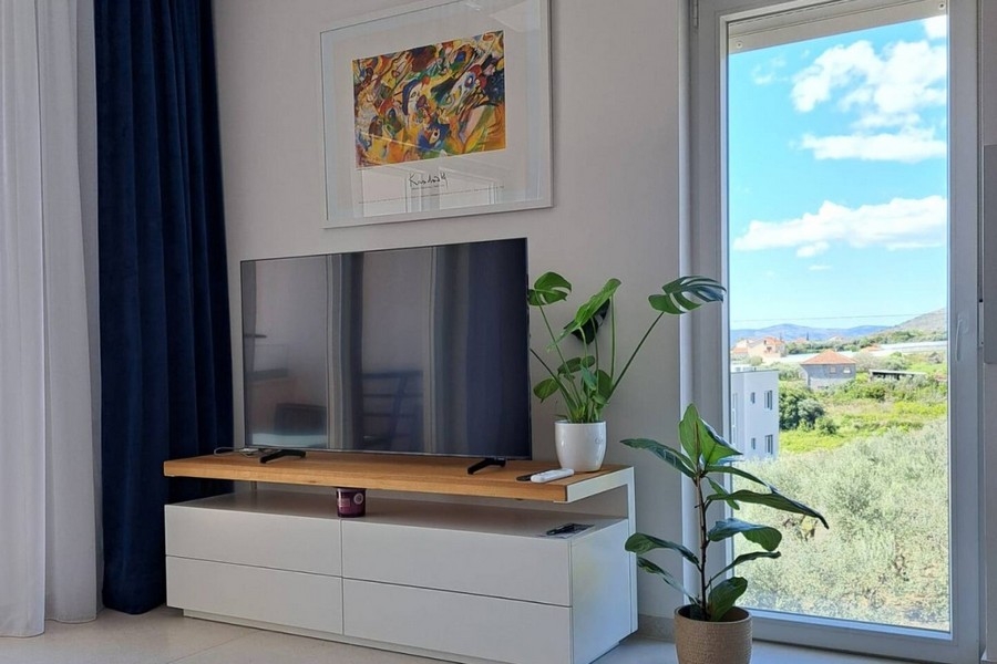 Obývacia izba s TV a veľkými oknami