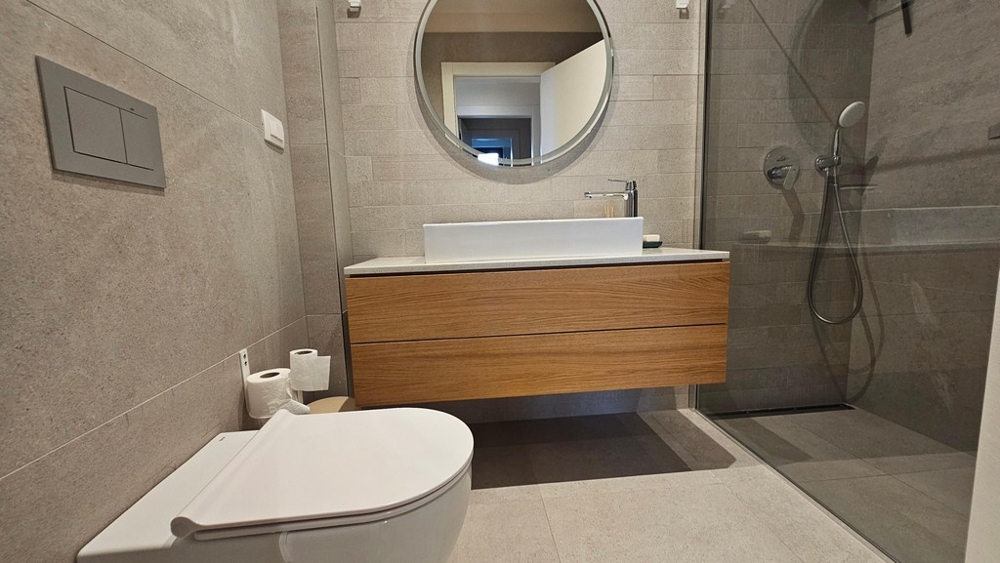 Moderná kúpeľňa so sprchovacím kútom a umývadlom