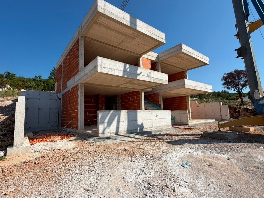 Hrubá stavba apartmánového domu so stavebným žeriavom