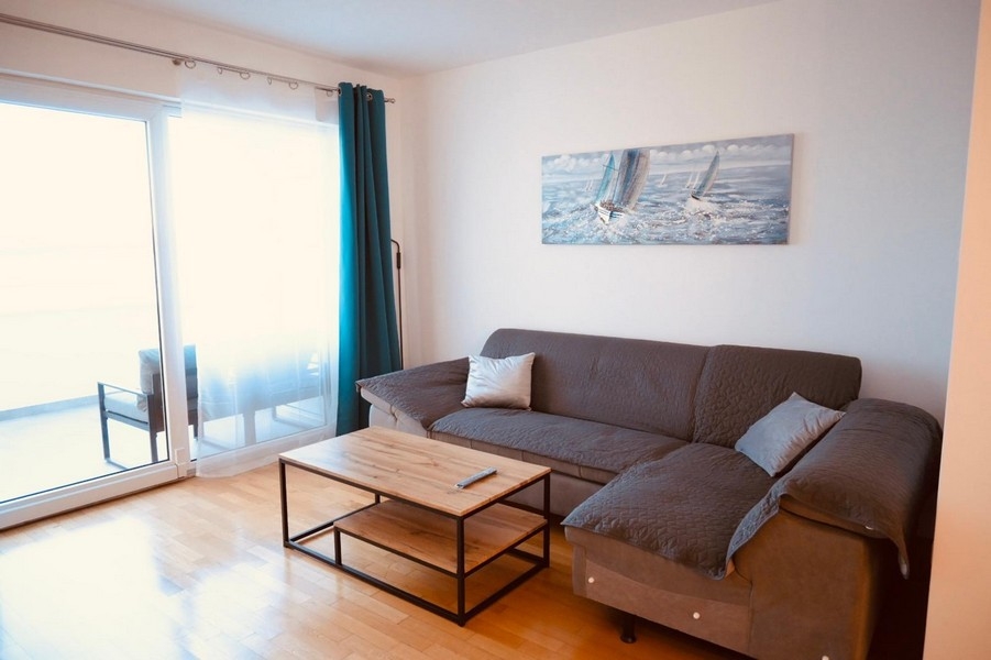 Obývacia izba s pohovkou a vstupom na balkón