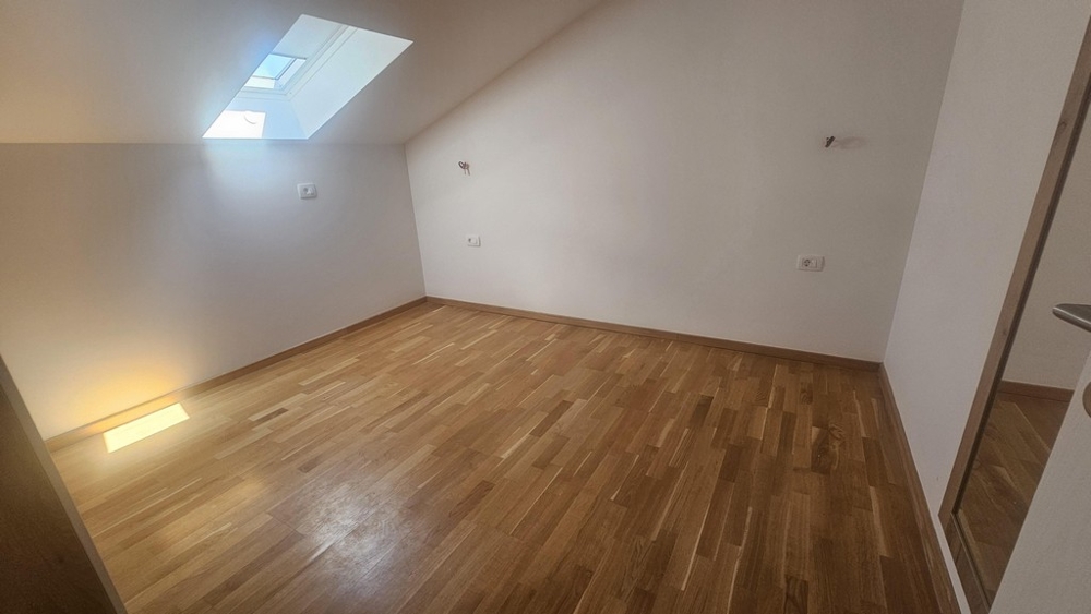 Izba so strešným oknom a drevenou podlahou
