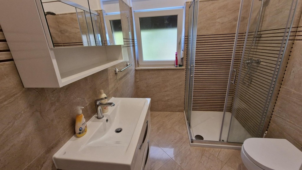 Kúpeľňa s umývadlom a sprchovacím kútom bytu v Njivice