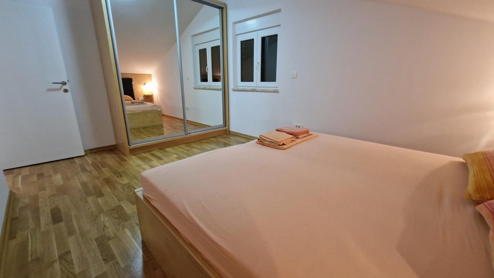Spálňa so zrkadlovým šatníkom v apartmáne na ostrove Krk