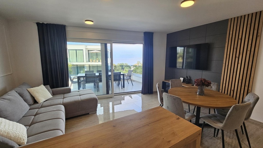 Obývacia časť s výhľadom na more cez okno pred apartmánom v Malinska