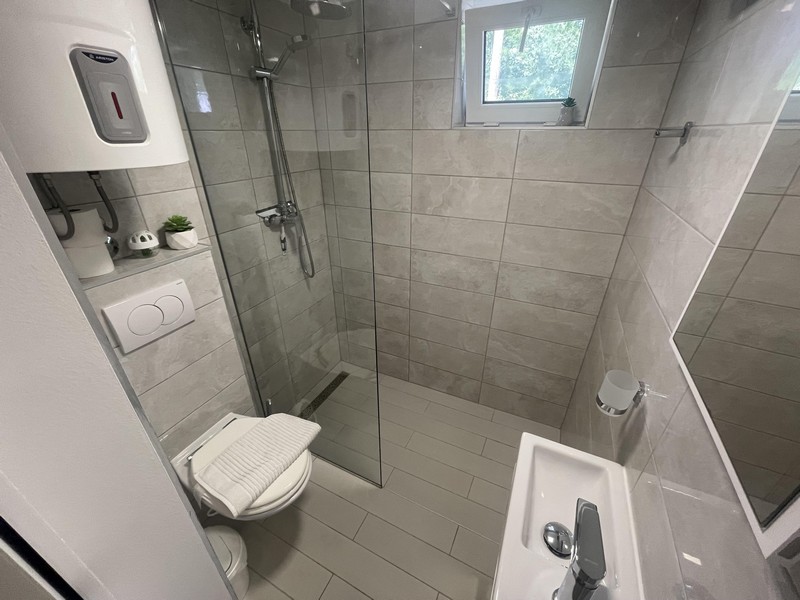 Kúpeľňa so sprchovacím kútom v byte v Njivice