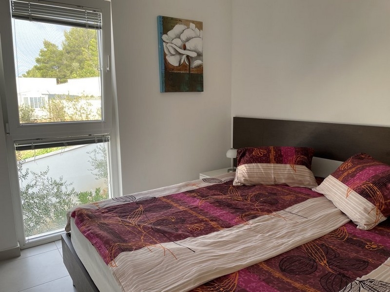 Spálňa apartmánu s výhľadom na more v Murter, Chorvátsko