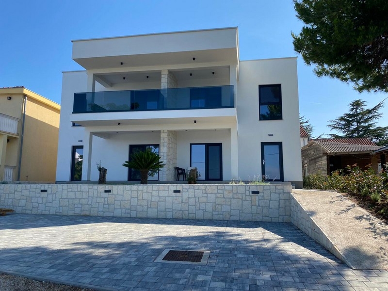 Pohľad spredu na vilu s terasou a parkovacími miestami