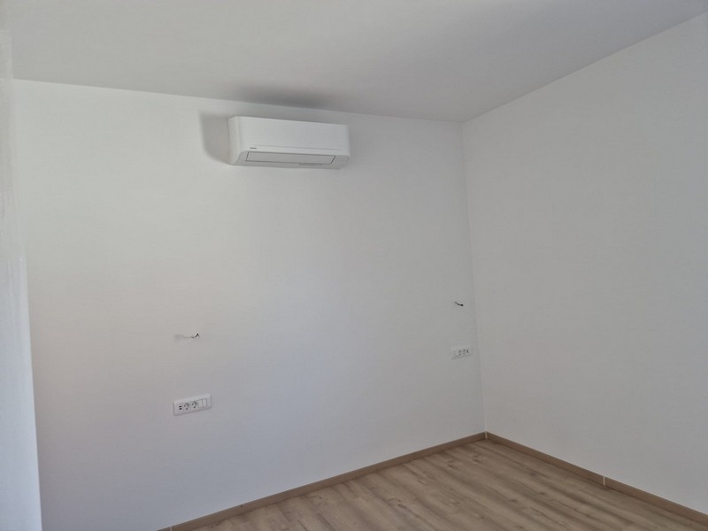 Izba s klimatizáciou a bielymi stenami