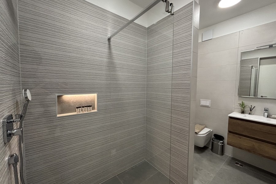 Kúpeľňa so sprchovacím kútom a umývadlom v Trogire