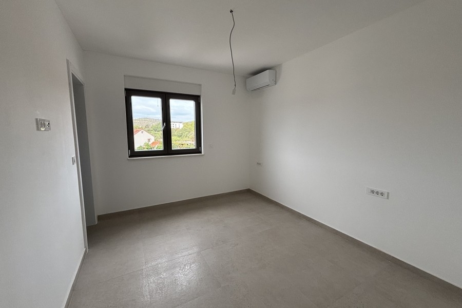 Spálňa s klimatizačnou jednotkou a oknom