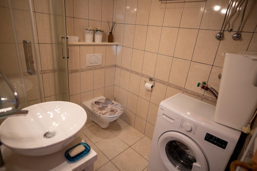 Kúpeľňa so sprchovacím kútom a práčkou