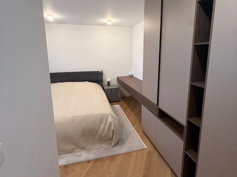 Spálňa s vstavanou skriňou a drevenou podlahou