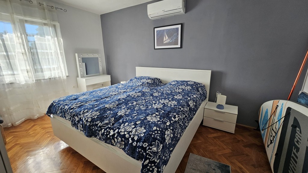 Spálňa s manželskou posteľou a klimatizačnou jednotkou
