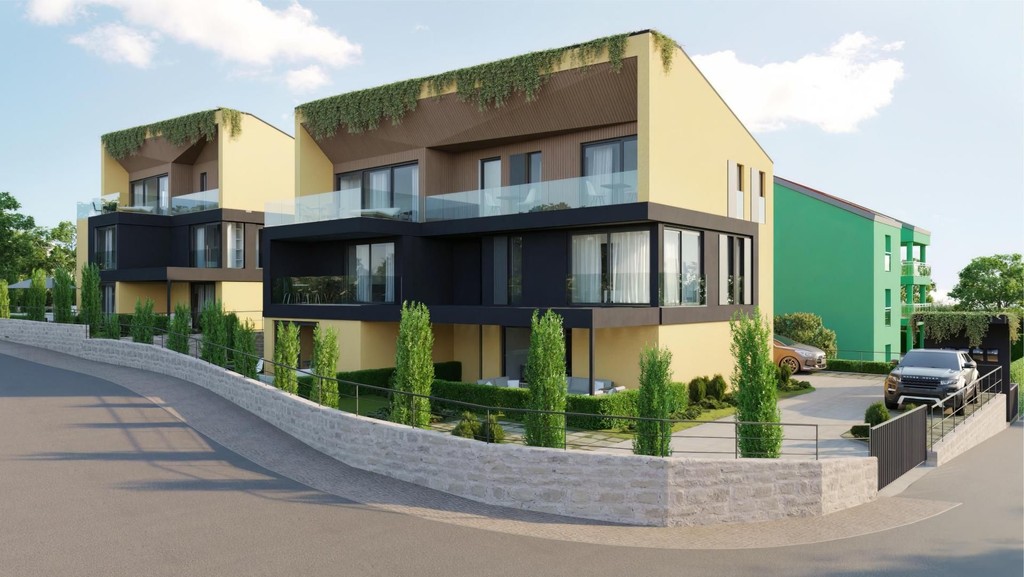 Novostavby so sklenenými balkónmi a zazelenenými okrajmi striech pri ceste