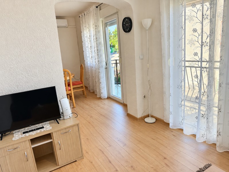 Obytná časť s televízorom a dverami na balkón