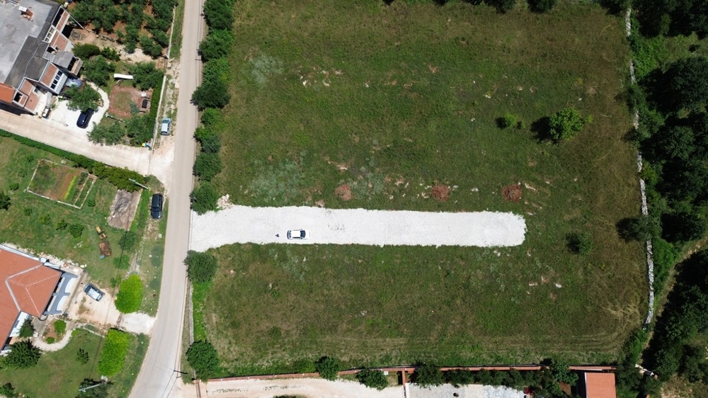 Letecký pohľad na nehnuteľnosť v Chorvátsku na Istrii obklopenú zelenými kopcami a výhľadom na more