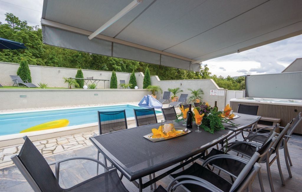 Terasa a bazén za domom s výhľadom na priľahlý les.