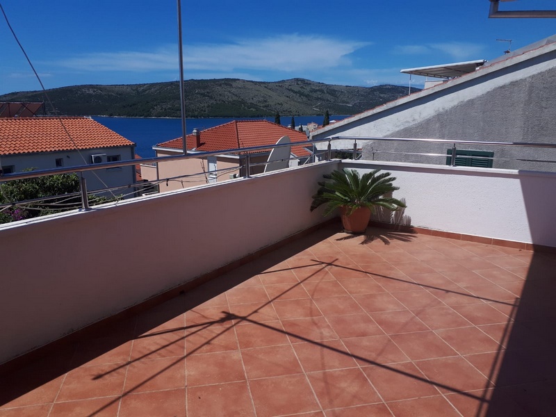 Obrázok krytej terasy so stolom a stoličkami