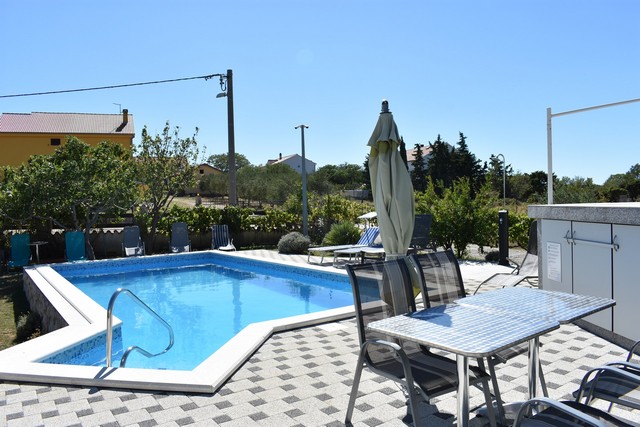 Pohľad z salónika na kúpalisko a záhradu v Chorvátsku.