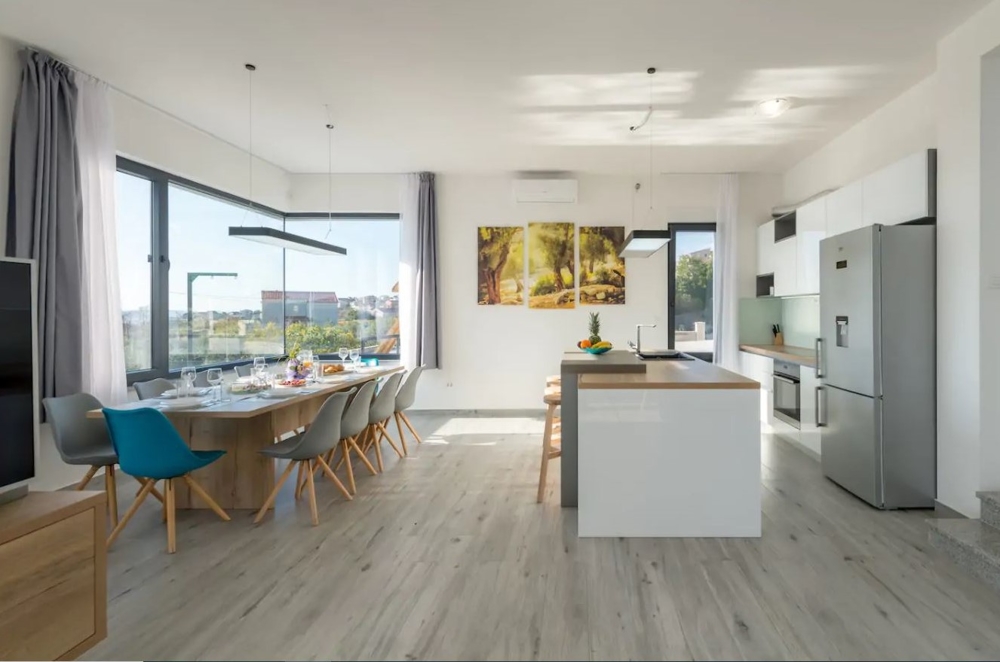 Moderný obývací priestor s otvorenou kuchyňou a jedálenským kútom.