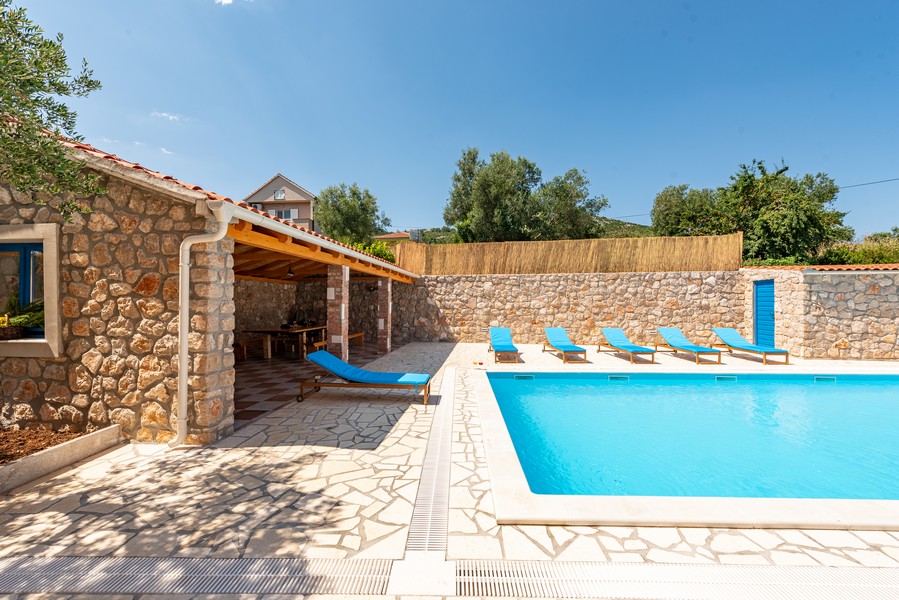 Kamenný dom s bazénom a priestorom na opaľovanie