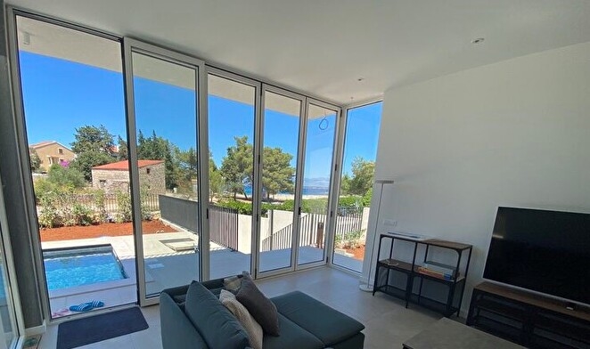 Obývacia izba s výhľadom na bazén.