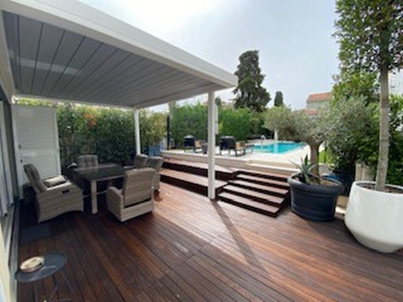 Polokrytá drevená terasa s výhľadom na bazén luxusnej vily na Istrii na predaj.
