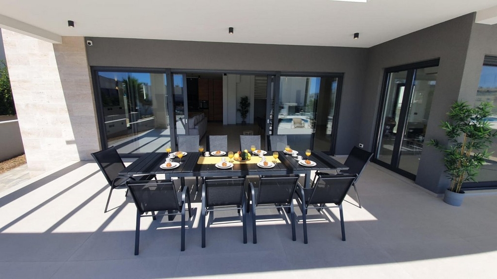 Moderná terasa s krytým jedálenským kútom.