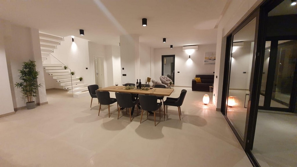 Otvorený priestor s jedálenským stolom a výhľadom na schodisko.