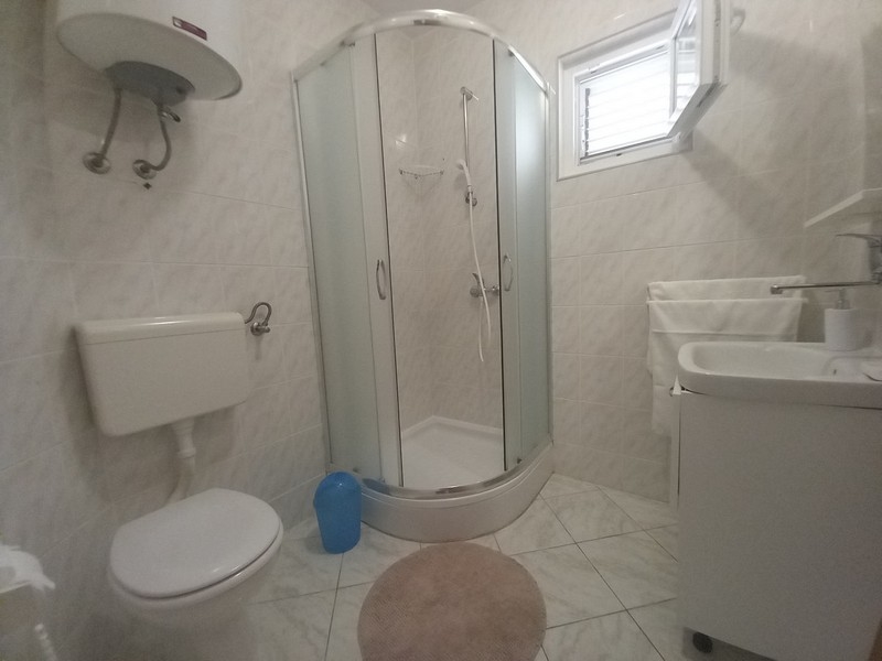 Svetlá kúpeľňa s WC a sprchovým kútom.